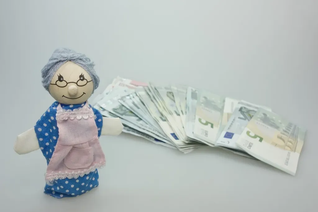 Szklana skarbonka z monetami i notatnik z wykresami finansowymi na biurku, symbolizujące planowanie oszczędności emerytalnych.